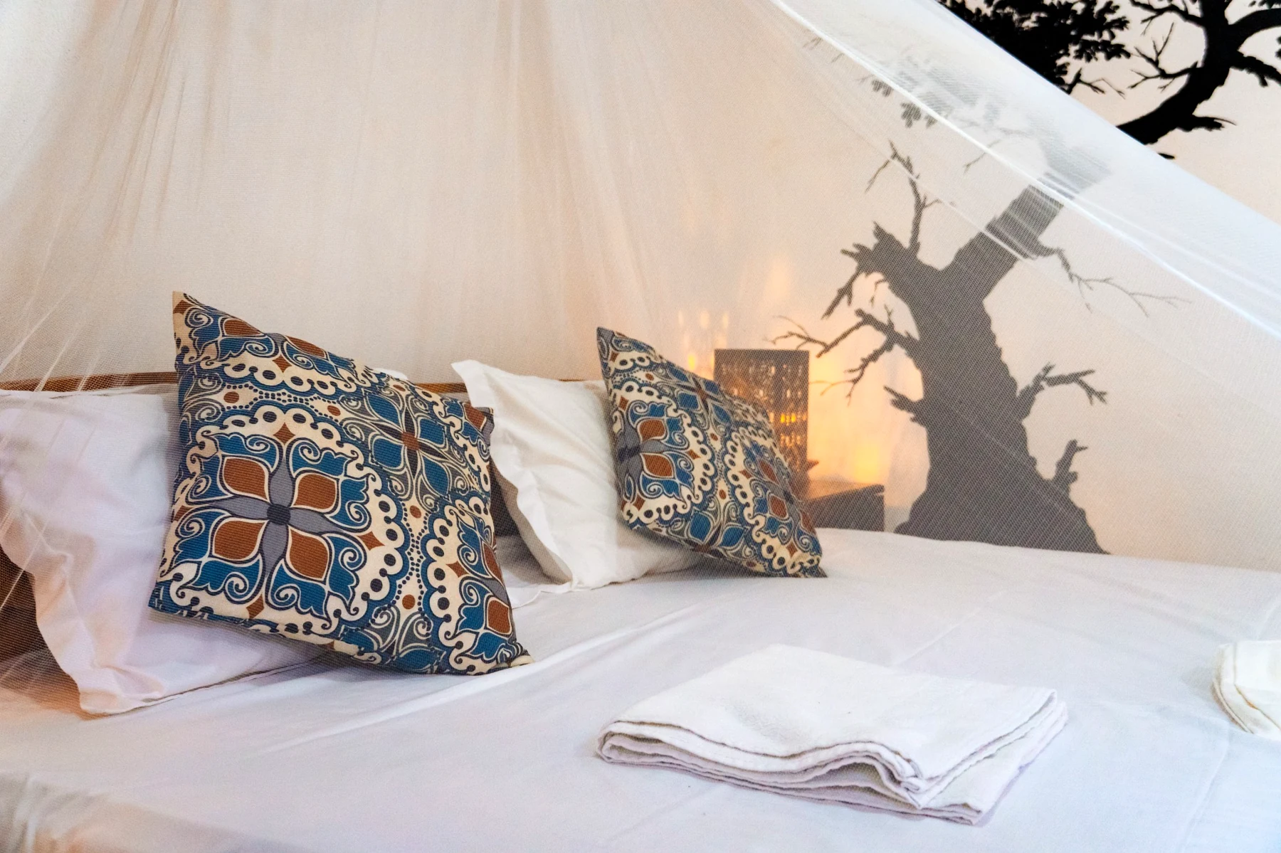 Mosquito net over the bed in the Poolside Comfort Chalet