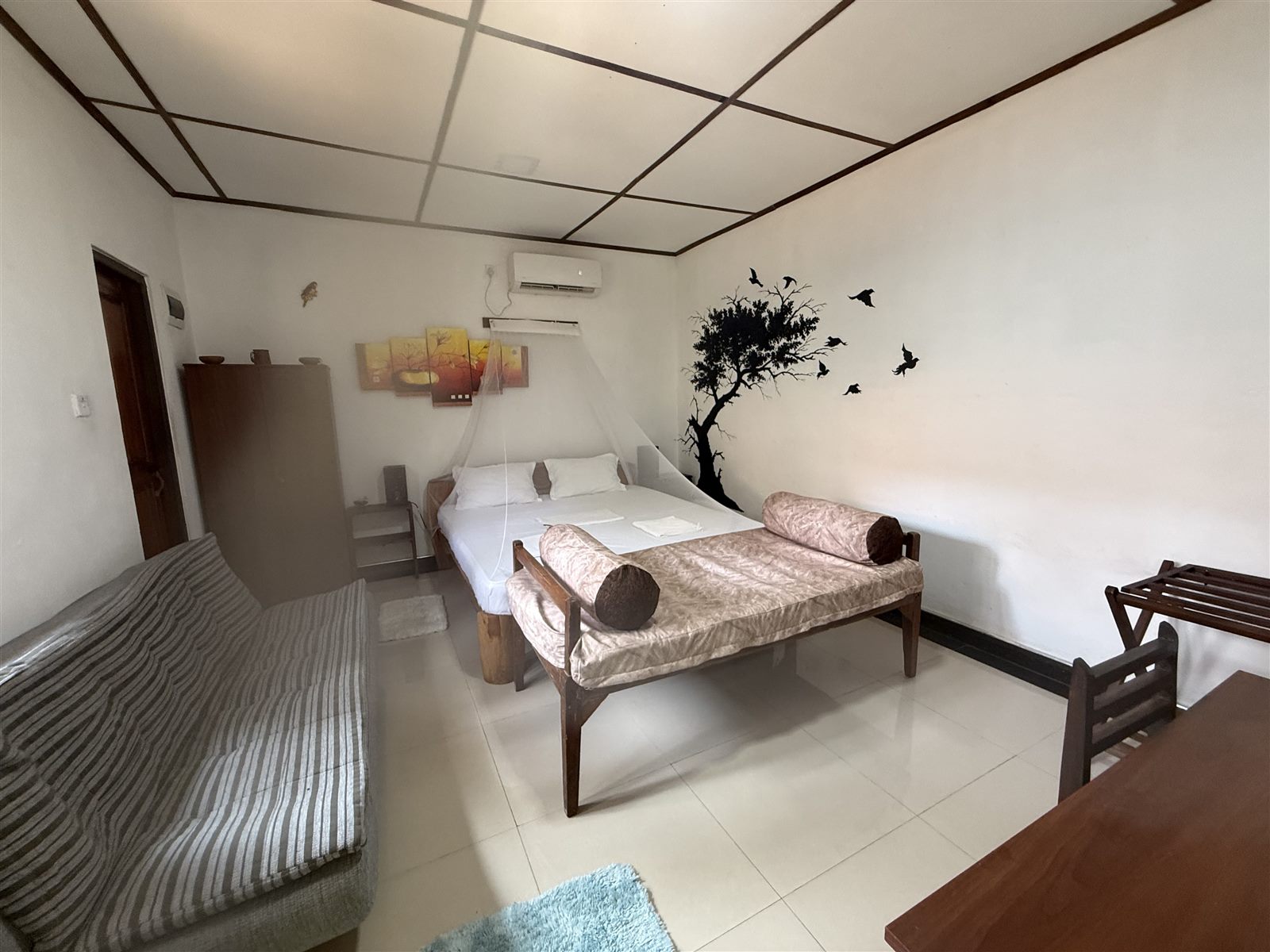 Wide view of the Poolside Comfort Chalet room with sofa and bed